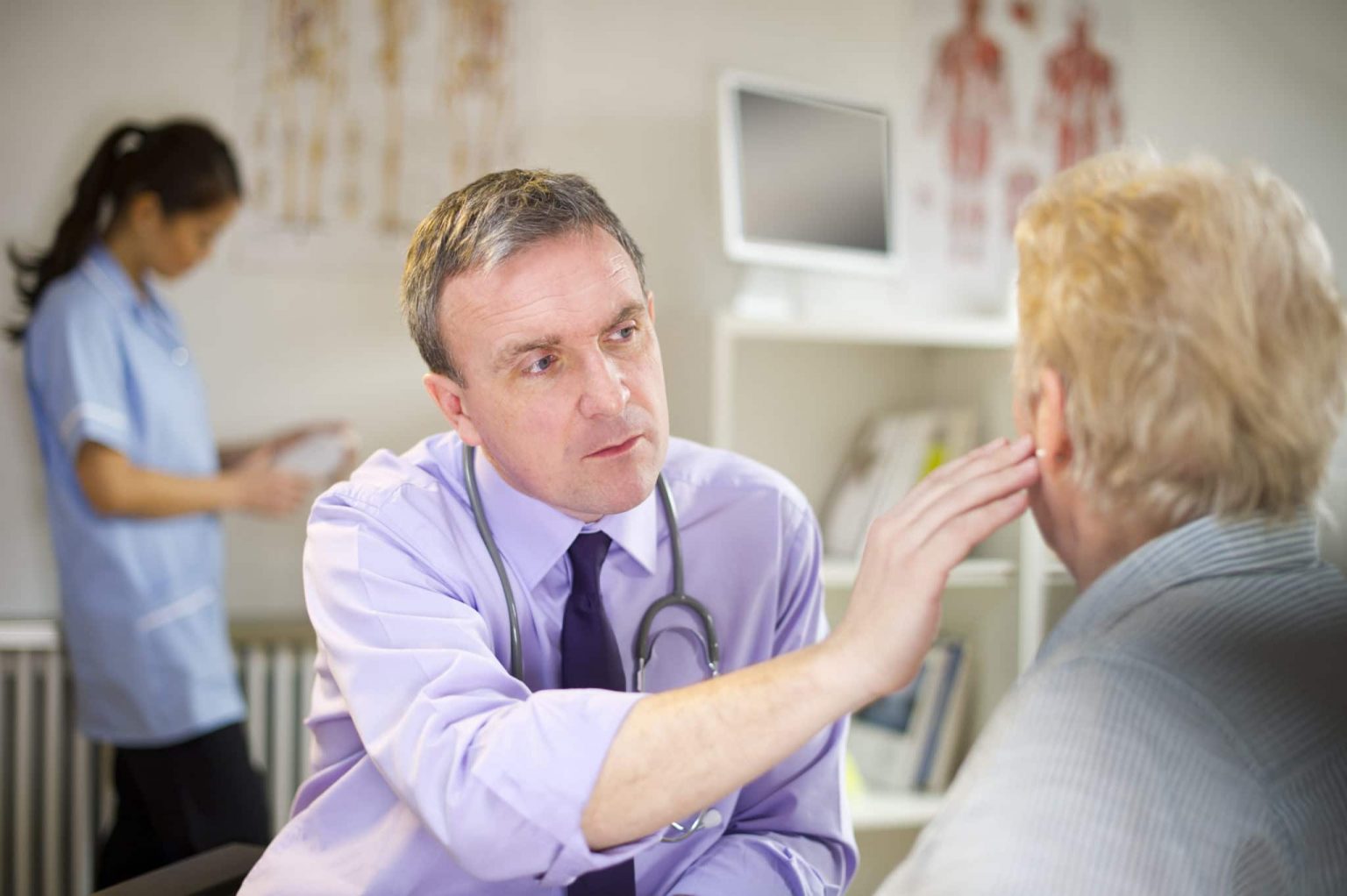 ENT inspecting a patients ears for earwax