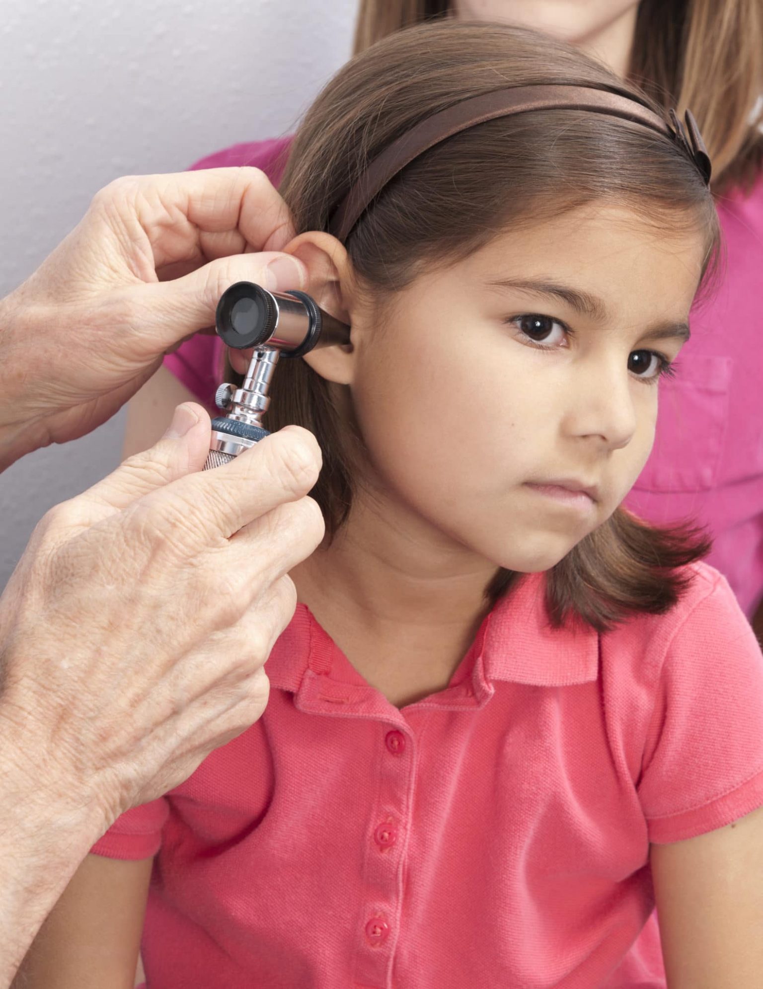 A young female patient being examined for an ear infection.